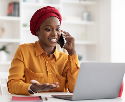 Woman on phone at laptop